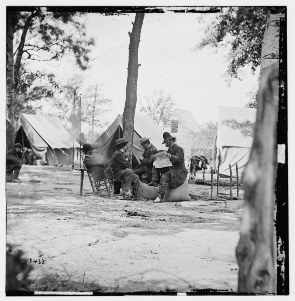Gen. Ambrose E. Burnside (reading newspaper) with Mathew B. Brady (nearest tree) at Army of the Potomac headquarters (Library of Congress LC-B811-2433)